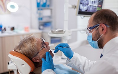 Dentist examining patient's smile in treatment room