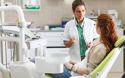 A woman consults her dentist about teeth whitening treatment